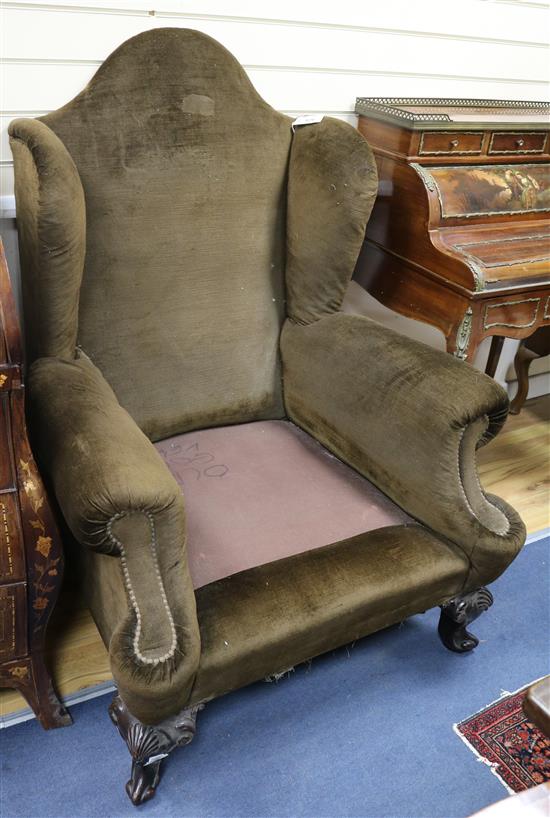 A pair of wing back armchairs, upholstered in brown dralon (lacking cushions)